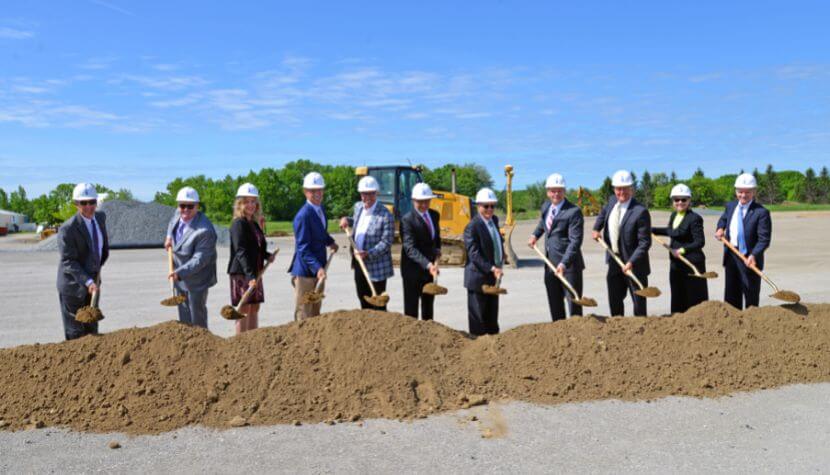 Team of workers wearing hard hats digging with shovels